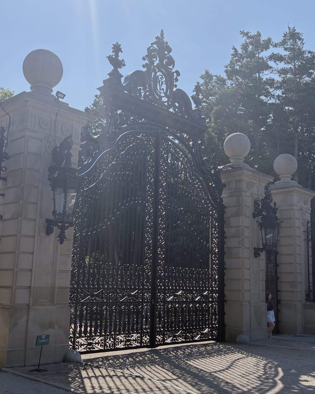 The wrought-iron entrance gate of The Breakers against a hard blue sky